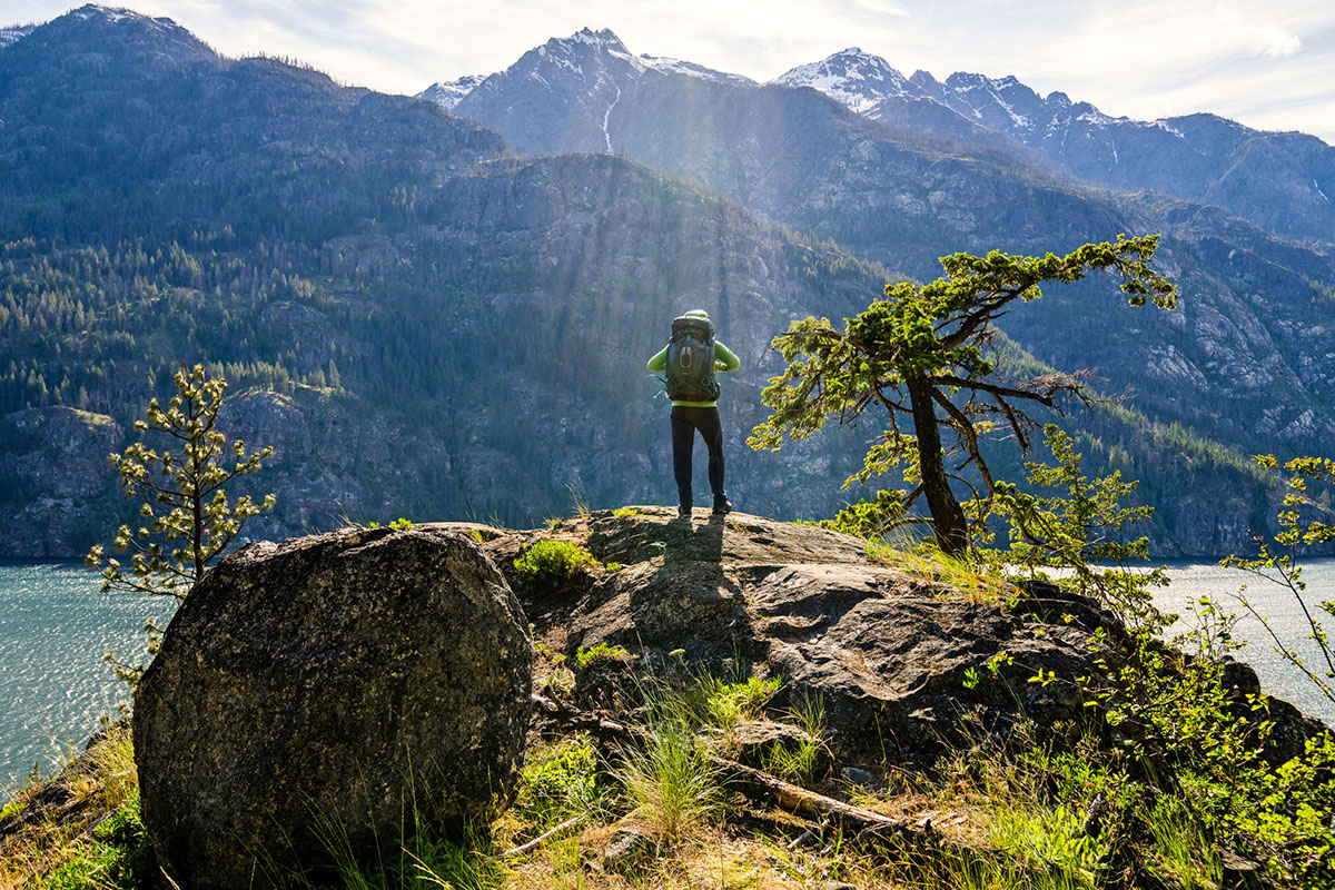 ​​Osprey Atmos AG 65 backpacking back (overlooking lake on rock)