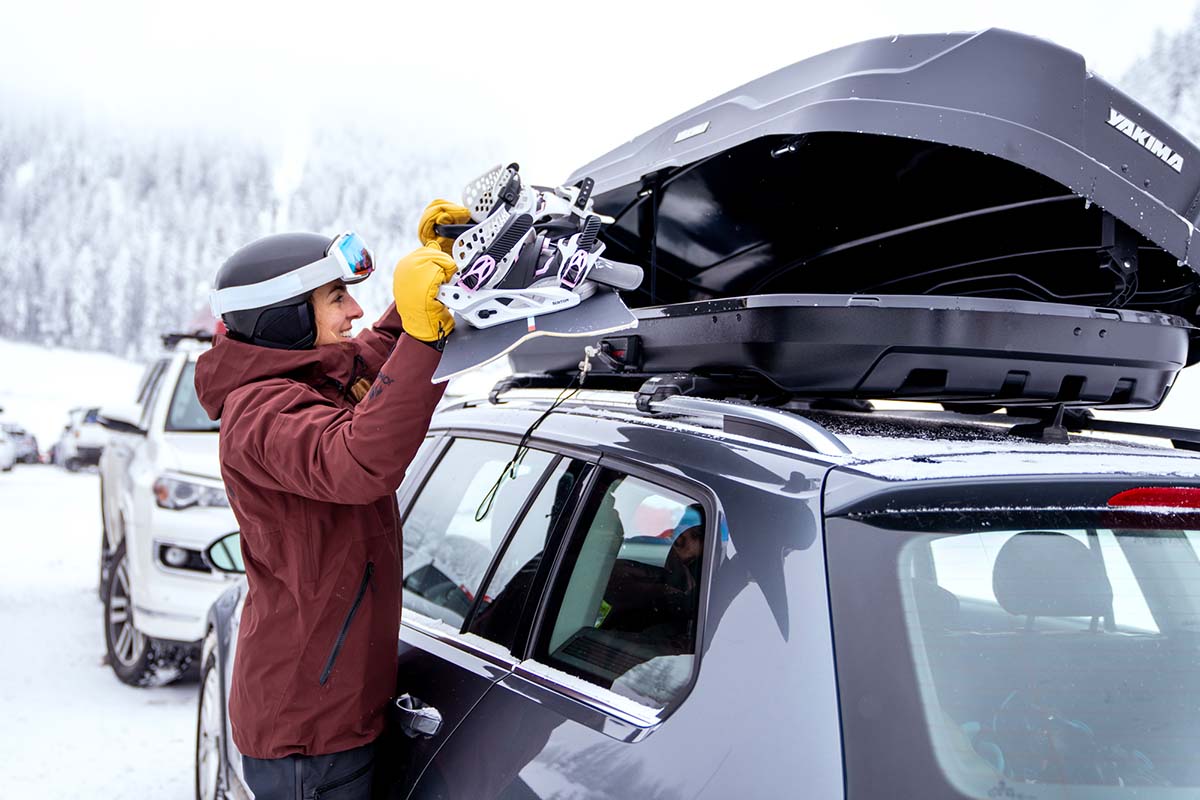 Loading a snowboard into a rooftop cargo box (Yakima SkyBox NX 16)