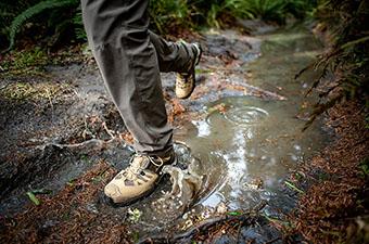 Salomon hiking footwear (Quest 4 GTX splashing through puddle)