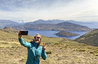 Taking selfie with mountain lake in background